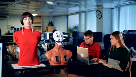 Two-engineers-are-observing-a-robotic-mannequin-moving-facial-organs