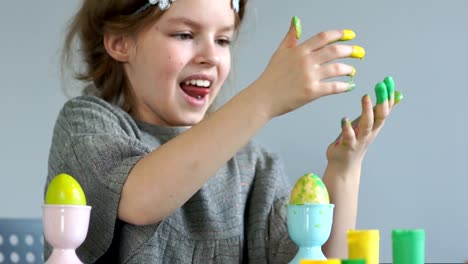 The-girl-draws-with-her-fingers,-paints-Easter-eggs