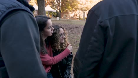 Two-young-women-students-hugging-and-sitting-next-to-each-other