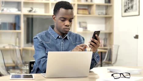 Hombre-africano-usando-smartphone-y-Laptop