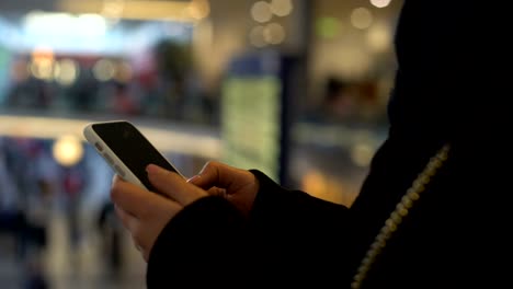 Female-typing-on-smartphone,-standing-in-shopping-center,-online-banking