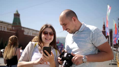 Happy-couple-tourists-walking-in-Moscow's-red-square,-admire-and-take-pictures.