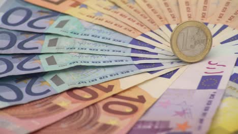 4K-Primer-plano-de-una-moneda-de-un-euro-con-billetes-de-diferentes-valores.-Dinero-en-efectivo