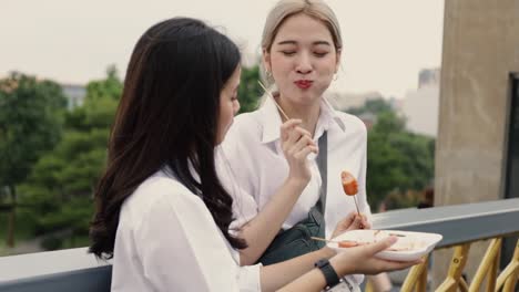 Asian-lesbian-couple-enjoying-traveling-in-Thailand-and-eating-meatball-having-fun-during-vacation-time.-LGBT-concept.