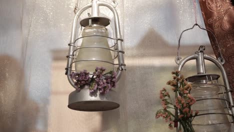 two-metal-silver-lamps-hanging-on-shiny-tulle-near-brown-curtain