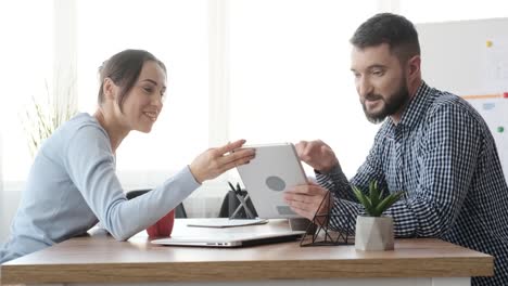 Geschäftskollegen-mit-digitalem-Tablet-im-Büro