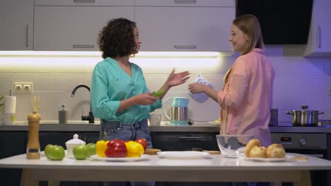 Beautiful-biracial-female-taking-vegetables-from-friend's-hand,-cooking-together