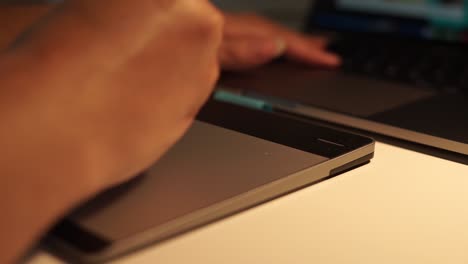 Close-up-view-of-graphic-designer-hand-using-graphics-tablet-working-over-night