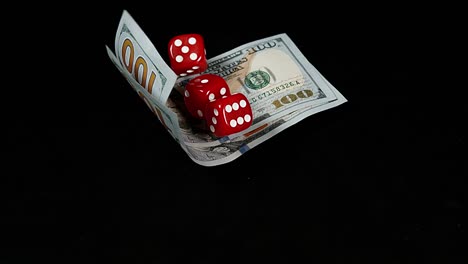 Red-Dice-rolling-on-Dollar-Bills-against-Black-Background,-slow-motion-4K