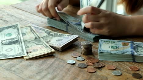 People's-hand-is-counting-US-Dollars-bank-notes.