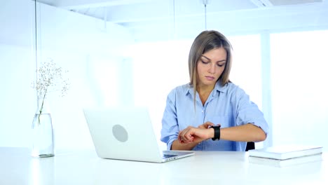 Young-Woman-Using-Smartwatch,-Sitting-in-Office