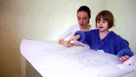 Young-mother-helps-daughter-with-drawing,-concentrated-girls-sitting-in-well-lit-room-discussing-occupation