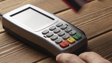 Person-pushing-the-button-and-swipe-credit-card-payment-on-pos-terminal