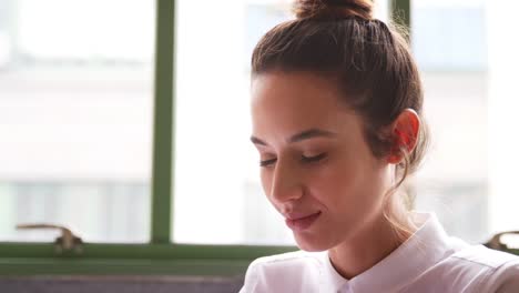 Young-woman-working-in-office,-head-and-shoulders-close-up