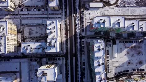 Luftbild-schneebedeckte-Straße-mit-Autos-im-Winter.-Clip.-Blick-auf-Stadt-Wintertag.-Stadtpanorama-mit-geraden-Straße-bedeckt-mit-Schnee-aus-einer-Vogelperspektive.-Winter-Straßen-der-Stadt-von-einem-Vogel-Augen-Blick