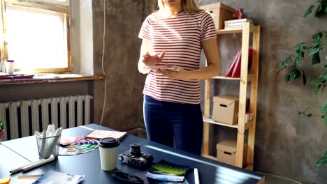 Tilt-up-shot-of-young-travel-blogger-making-pictures-of-her-desk-with-smart-phone.-She-is-moving-different-things-on-her-table-and-shooting-it.