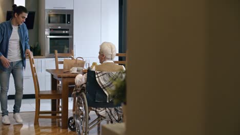 Young-Man-Giving-Coffee-to-Senior-Lady