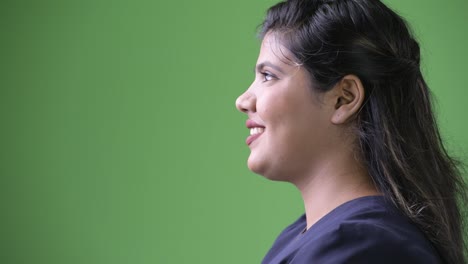 Young-overweight-beautiful-Indian-businesswoman-against-green-background