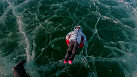 Man-is-turning-woman-on-ice.-Father-turns-his-daughter-and-her-mother-on-an-ice.-Family-has-fun-and-sports-time-in-nature.-Rotate-people.-Slow-motion.