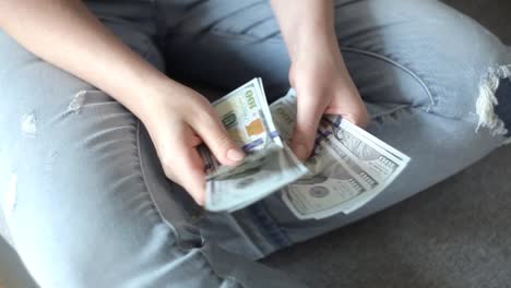 Closeup-of-woman-hands-counting-new-100-US-dollar-banknotes