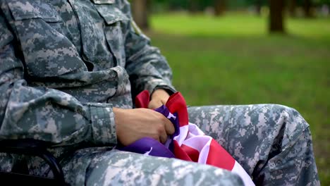 Herido-a-soldado-americano-con-una-bandera-nacional-en-el-pensamiento-de-las-manos-de-guerra,-recuerdos