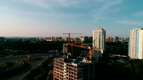 the-construction-crane-and-the-building-against-the-blue-sky