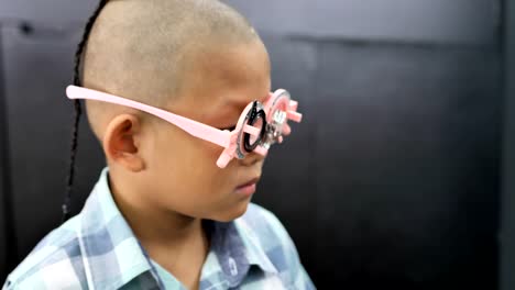 eyesight-check.-Asian-boys-who-have-vision-disabilities.-Left-eye-is-not-visible-from-brain-surgery.-Medical-treatment-and-Rehabilitation.-video-4k