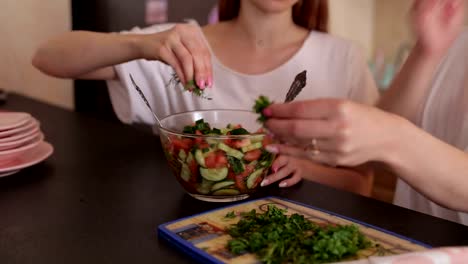 Dos-hermosas-niñas-preparan-una-ensalada-de-verduras-en-la-cocina.