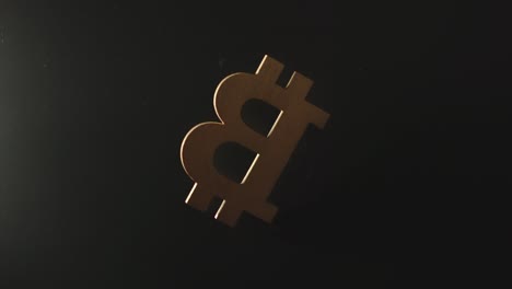 SLOW-MOTION:-Wooden-bitcoin-symbol-falls-in-darkness