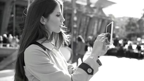 Pretty-Caucasian-woman-communicating-by-sending-text-messages-on-digital-tablet-in-black-and-white