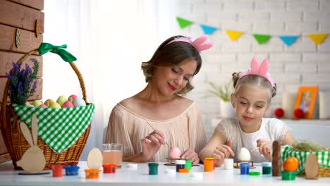 Daughter-and-mother-in-cute-headbands-having-fun-painting-nose-to-each-other