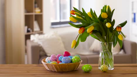 huevos-de-Pascua-en-cesta-y-tulipán-flores-en-casa