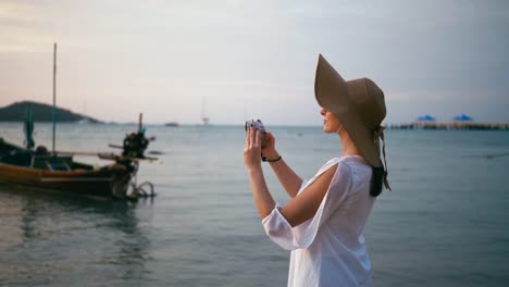 Schöne-Frau,-die-das-Fotografieren-mit-Smartphone-Technologie-am-Paradiesstrand