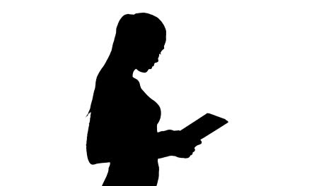 Silhouette-Attractive-businesswoman-using-a-digital-tablet-while-walking