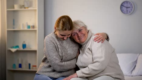 Fürsorgliche-Mädchen-umarmt-deaktiviert-Großmutter,-unterstützende-Beziehungen-in-Familie