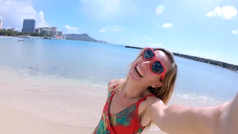 Selfie-von-Mädchen-mit-Herz-geformt-Sonnenbrille-am-Strand-von-Hawaii.-Junge-Frau,-die-eine-Selfie-am-Strand-von-Waikiki-in-Honolulu.-Hawaii-USA