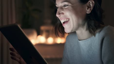 Woman-having-fun-using-digital-tablet-at-night