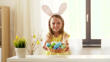 Chica-feliz-mostrando-color-huevo-de-Pascua-en-casa