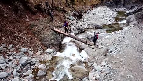 Drone-tracking-couple-of-hikers-on-siberian-mountain-ridge-trail-in-Russia-walking-along-the-river-with-mountains-on-the-background