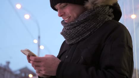 Mann-messaging-auf-dem-Handy-im-winter