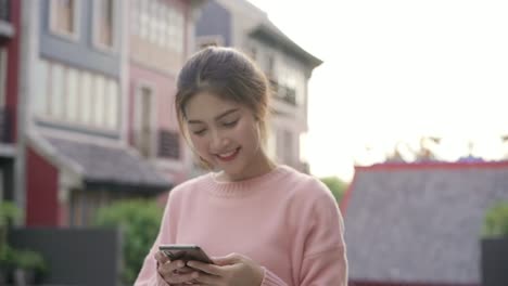 Cheerful-beautiful-young-Asian-backpacker-blogger-woman-using-smartphone-taking-selfie-while-traveling-at-Chinatown-in-Beijing,-China.-Lifestyle-backpack-tourist-travel-holiday-concept.