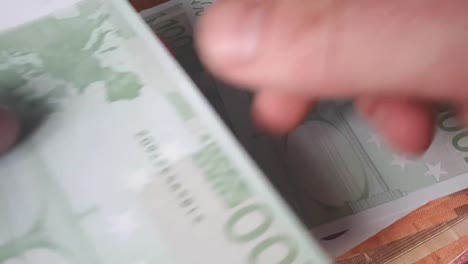 Man-Counting-100-Euro-Banknotes