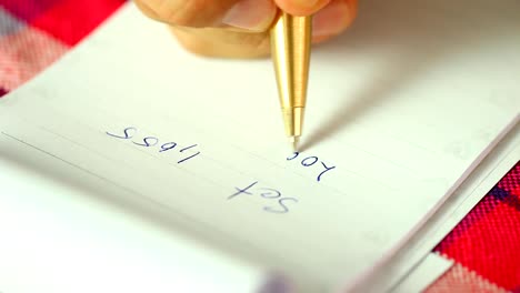 Man-writing-set-index-of-stock-exchange-on-the-notebook