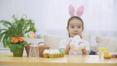 Pequeña-chica-linda-y-adorable-está-sonriendo-y-jugando-con-las-orejas-de-conejito.-Concepto-vacaciones-de-Pascua.