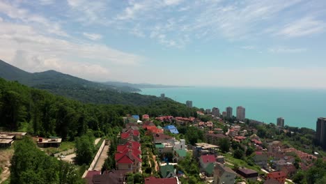 Aerial-video-shooting.-Flying-over-a-residential-area.-The-city-resort-of-Sochi.-Black-sea-coast.-Green-forest-and-mountains-by-the-sea.