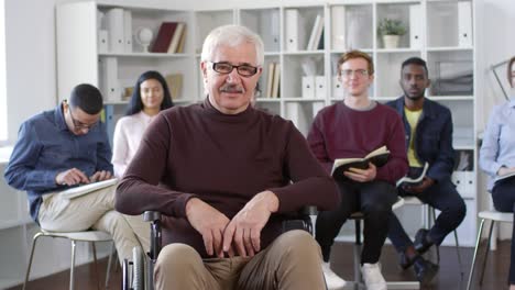 Porträt-der-Lehrerin-sitzt-im-Rollstuhl-im-Klassenzimmer