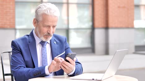 Old-Businessman-Excited-for-Success-on-Phone