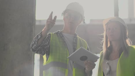 Ingenieure-oder-Architekten-diskutieren-auf-der-Baustelle-über-den-Bebauungsplan.-contre-jour.-Ingenieure-oder-Architekten-diskutieren.