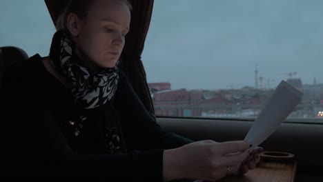 Frau-im-Zug-arbeiten-mit-Dokumenten-und-Tablet-PC