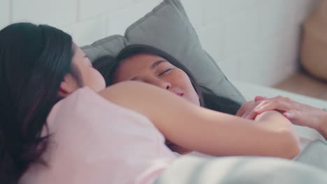 Asian-Lesbian-couple-relax-rest-together-after-wake-up-lying-on-bed-in-bedroom.